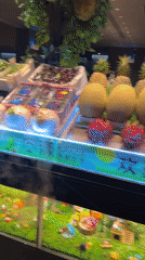 Woman gives Thai greeting at tropical fruit display in Pudong