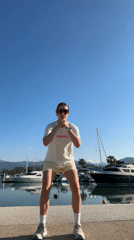 Woman exercises on pier at Turkish harbor during sunrise