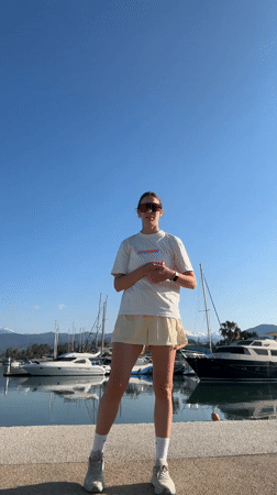 Woman exercises on pier at Turkish harbor during sunrise