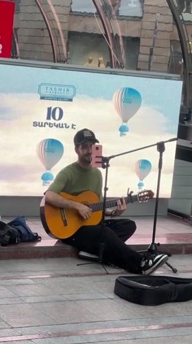 Street musician, waterfront dining captured in afternoon Yerevan scenes