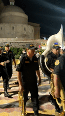 Police marching band performs at nighttime parade in Tacna