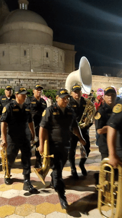 Police marching band performs at nighttime parade in Tacna