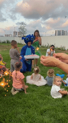 Stitch costume, sparklers, and kids at a backyard birthday party