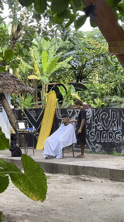 Outdoor barber service documented in General Luna, Philippines