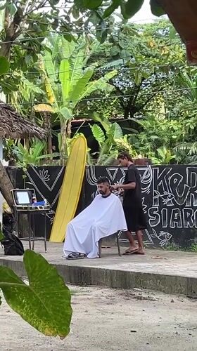 Outdoor barber service documented in General Luna, Philippines