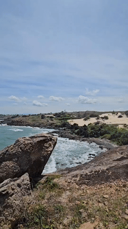 Morning at Mui Ne's rocky coastline, waves and rock cairns