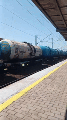 Blue tanker train passing through Artyom station on a clear day