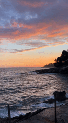 Person walks rocky Montenegro coastline during Adriatic sunset