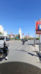 Street scene documented in Meknès featuring minaret and flags