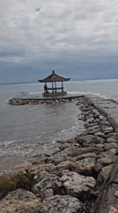Early morning beach activity captured along Denpasar's rocky coastline