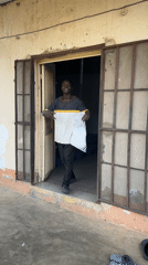 Young man with plastic bag makes peace signs in Jos