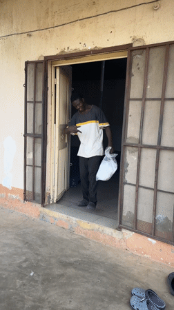 Young man with plastic bag makes peace signs in Jos