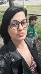 Woman takes street selfie as boy walks behind