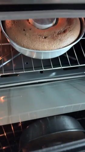 Home baker checks chocolate ring cake progress in Mexican kitchen