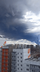 Storm clouds gather over residential cityscape from high vantage