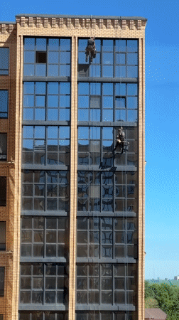 Window washers clean tall building in Kokshetau, Kazakhstan
