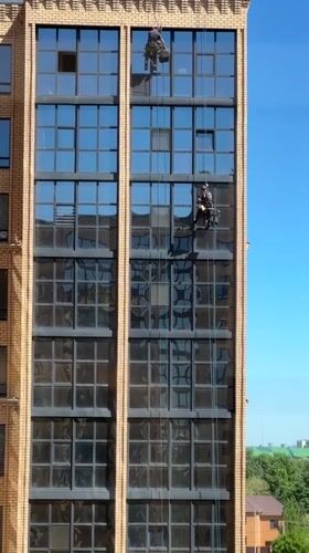 Window washers clean tall building in Kokshetau, Kazakhstan