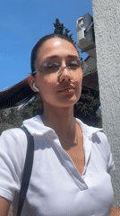 Woman in white shirt and sunglasses observed outdoors in Bar
