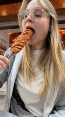 Woman enjoys corndog with condiments in Amman
