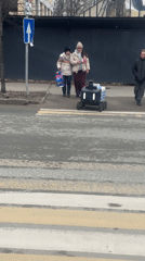 Delivery robot crosses crosswalk in Kazan as pedestrians watch
