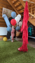 Toddler celebrates with balloons in rustic Russian home