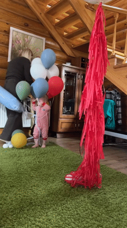 Toddler celebrates with balloons in rustic Russian home