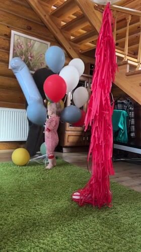 Toddler celebrates with balloons in rustic Russian home