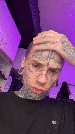 Heavily tattooed face under purple lighting in Buenos Aires
