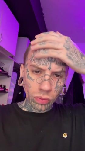 Heavily tattooed face under purple lighting in Buenos Aires