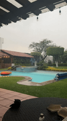 Person films backyard pool during nighttime rainfall