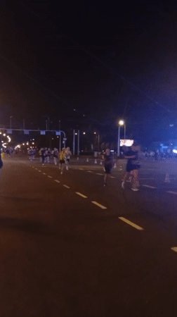 Night marathon runners traverse wet streets in Wrocław