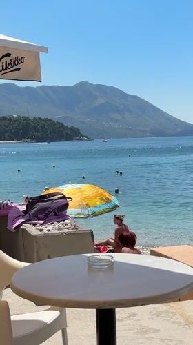 Summer morning on the Budva waterfront — beach, boats, and parasails