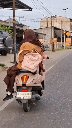 Pink scooter duo rolling through Keudebayu roads