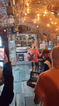 Live bass and vocals in front of a stocked bar