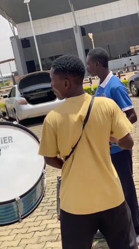 Musicians perform outdoors near arrivals building in Nigeria