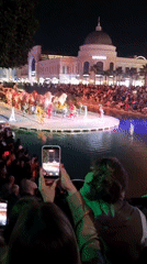 Attendee records nighttime performance on smartphone in Serik, Turkey