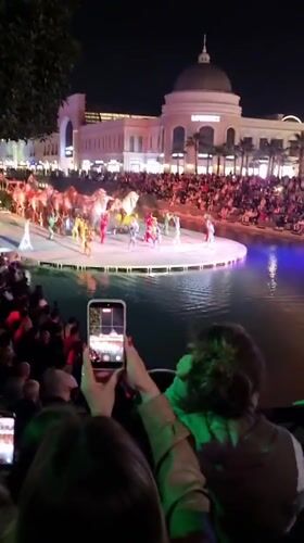 Attendee records nighttime performance on smartphone in Serik, Turkey