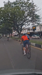 Cyclist films group ride from car in Santan, Indonesia