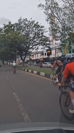 Cyclist films group ride from car in Santan, Indonesia