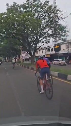 Cyclist films group ride from car in Santan, Indonesia