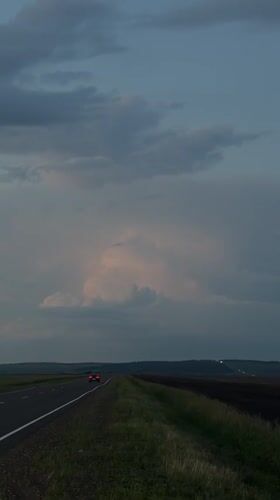 Dusk driving on a stormy rural highway near Kurgany, Russia