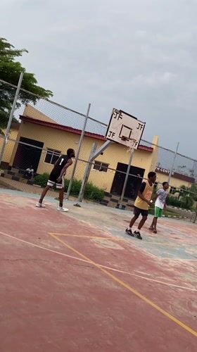 Young men play basketball on outdoor court in Lagos