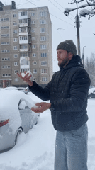 Man juggles snowballs in Murmansk street scene