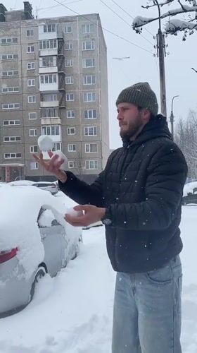 Man juggles snowballs in Murmansk street scene