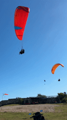Paragliders launch from Indonesian coastal cliffs under clear skies