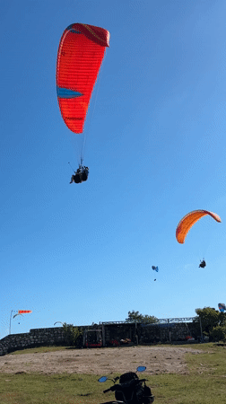 Paragliders launch from Indonesian coastal cliffs under clear skies