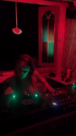 Woman DJs in small booth in Málaga early morning