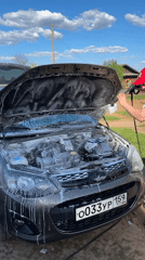 Car engine compartment sprayed with foam in Russian village