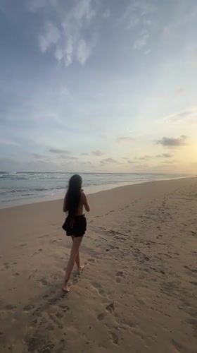 Woman and dog enjoy sunset beach walk in Sri Lanka
