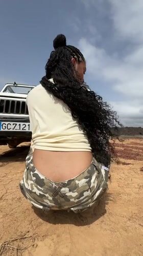 Woman crouches beside white Jeep in Tinajo, Spain
